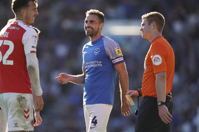 Referee James Oldham speaks to Pompey skipper Clark Robertson during the 1-1 draw with Fleetwood.
