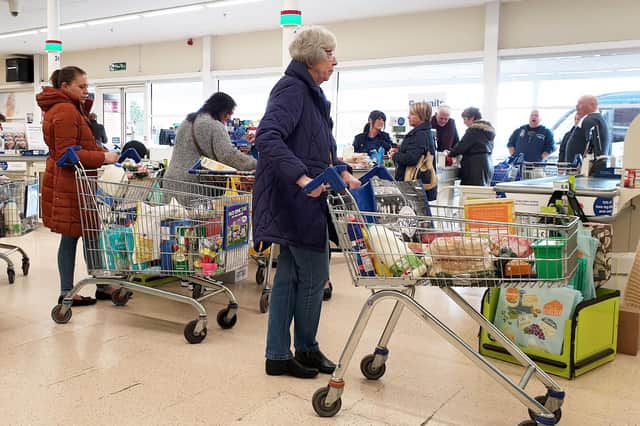 An elderly lady queues to pay for her shopping at a supermarket 
Pic: Gareth Fuller/PA Wire