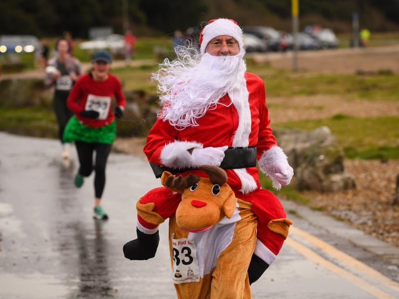 Stuart Wood celebrates crossing the finishing line in his Santa and Rudolph costume at the Christmas Pud 5k, Stokes Bay, Gosport