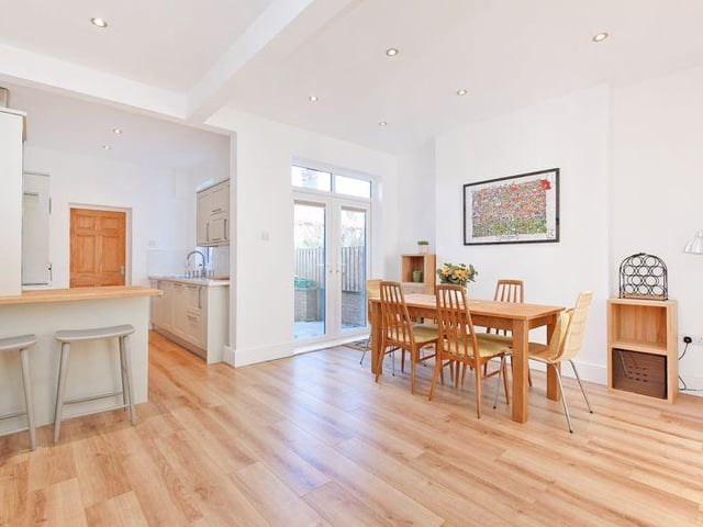 The kitchen, living and dining area has wood-effect laminate flooring throughout.