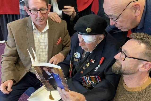 Undated family handout photo issued by the Blind Veterans UK of Ken Hobbs reading his 100th birthday card from King Charles III. Margaret Wilson, a codebreaker at Bletchley Park and Ken Hobbs, who served during D-Day, have celebrated their 100th birthday together after discovering they were born on the same day. Issue date: Monday February, 13 2023.