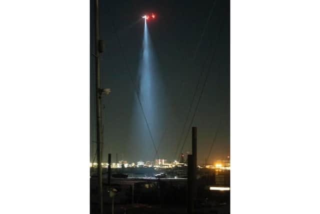 The Solent Coastguard helicopter above Portsmouth Harbour on Tuesday evening. A man was taken to hospital with burns after a gas explosion on his 26ft boat near Hardway Marina Picture: Jon Nash