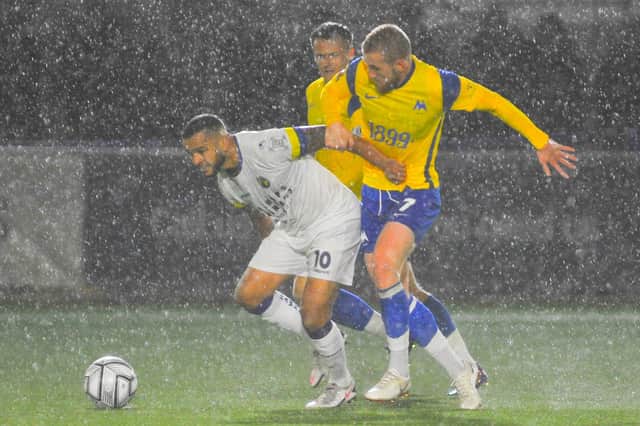 Hawks' Billy Clifford and Torquay's Connor Lemonheigh-Evans battle for possession as the rain lashes down at Westleigh Park. Picture: Martyn White