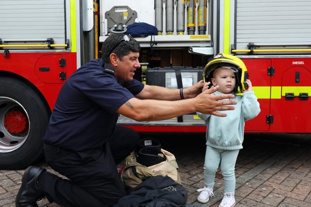 Firefighter Phil 'Larry' Lamb helps Louie Wiggins, 2, try on a firefighter's helmet. 999 Day at Port Solent
Picture: Chris Moorhouse (jpns 030922-08)