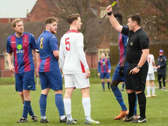 Horndean's Ethan Robb is booked by referee Harry Scott. Picture: Keith Woodland