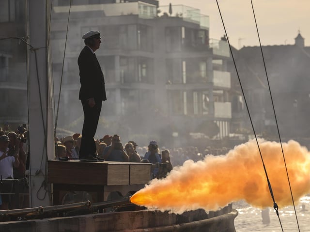 A gun salute takes place from the Royal Yacht Squadron as HMS Queen Elizabeth enters the Solent off of Cowes.