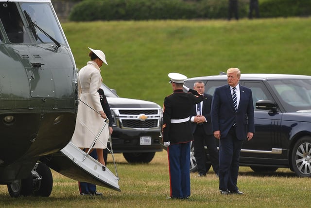 US President Donald Trump (R) and First Lady Melania Trump (L) disembark from the Marine One helicopter after arriving at Southsea Castle.