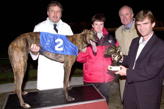 Golden Muzzle - Winner Jicky (No. 2) with kennel hand Nigel Wareham (left), trainer Brian Clemenson (far right) and assistant trainer Carolyn Sallis (centre), receiving the trophy from Peter Shrees (right) after final at Portsmouth Greyhound Stadium, Target Road, Tipner. Picture: Mike Scaddan. 005949_0067