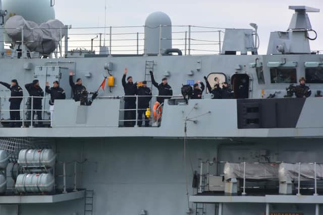 The crew of HMS Lancaster wave to family and friends at the entrance to Portsmouth Harbour.
