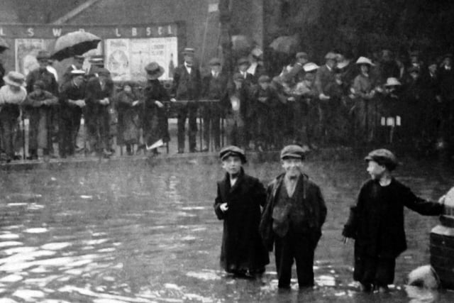 The boy’s face in the centre says it all. Flooding in Commercial Road taken from inside the gates of the railway goods shed. Undated
