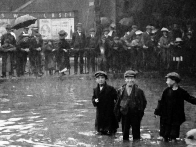 The boy’s face in the centre says it all. Flooding in Commercial Road taken from inside the gates of the railway goods shed. Undated