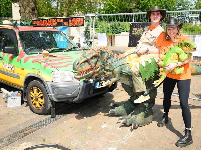 Sam Adams and Emily Potter with dinosaurs from rental dinosaurs at the Jurassic Park stand. Picture: Keith Woodland (110521-184)
