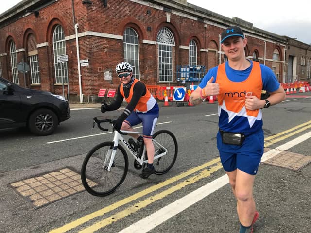 Able Rate Eddy Eggleton, right, is running seven marathons in seven days this week in a bid to raise money for the Motor Neurone Disease Association. He is pictured with Tom Galloway, who is cycling next to him as his support.  Photo: Royal Navy