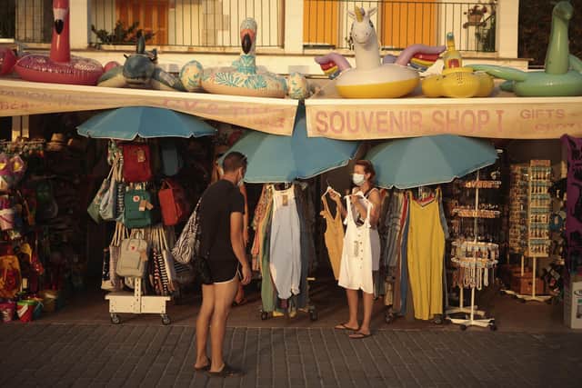 A woman shops for dresses in town of Sóller in the Balearic Island of Mallorca, Spain. Picture: AP Photo/Joan Mateu