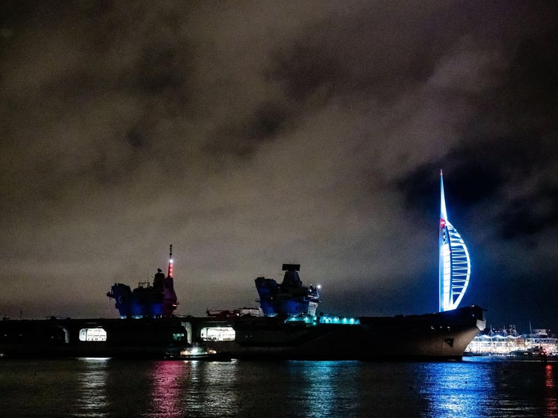 HMS Queen Elizabeth sailing past the Spinnaker Tower illuminated in colours for Elin Martin.