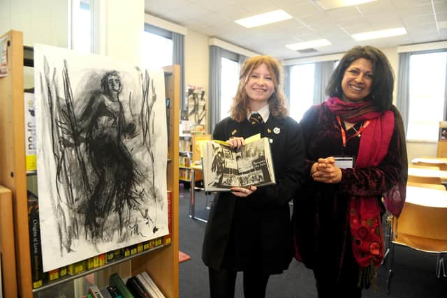 On International Women’s Day, Portsmouth Grammar School welcomed author Sita Brahmachari who took part in a variety of projects with pupils from across the school. Pictured is: Sophie Matheson (17) showing her artwork to author Sita Brahmachari. Picture: Sarah Standing (080322-522)