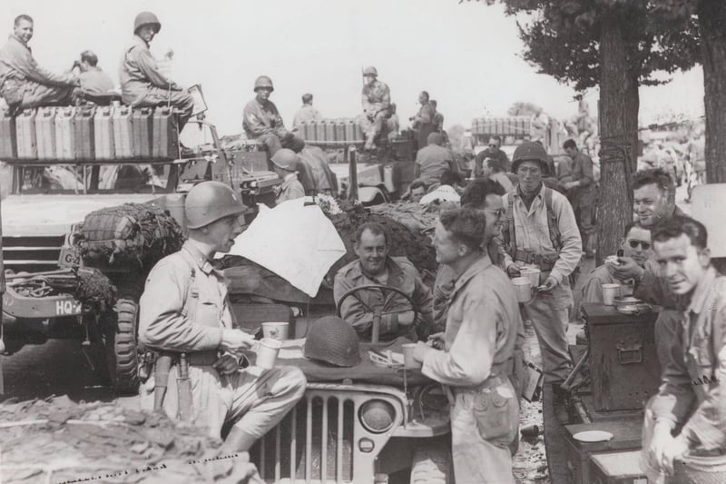 US troops having a roadside break. The number of fuel (jerry) cans carried by the vehicles on the left suggests they are going quite a distance.