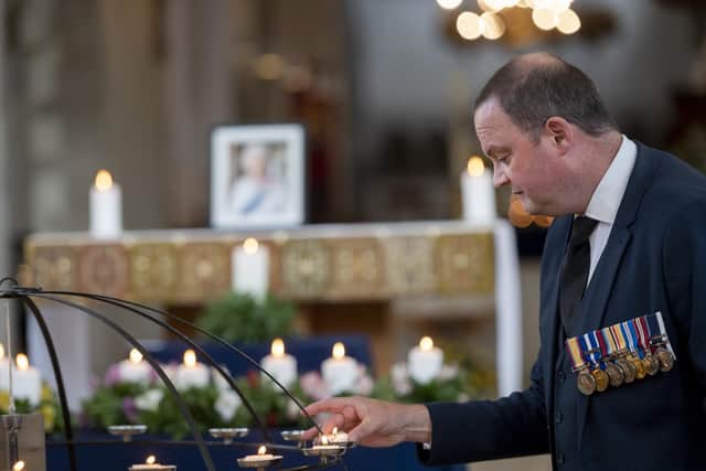 Simon Weaver lights a candle at the service of Commemoration and Thanksgiving for the Life of Her Late Majesty Queen Elizabeth II, Portsmouth Cathedral