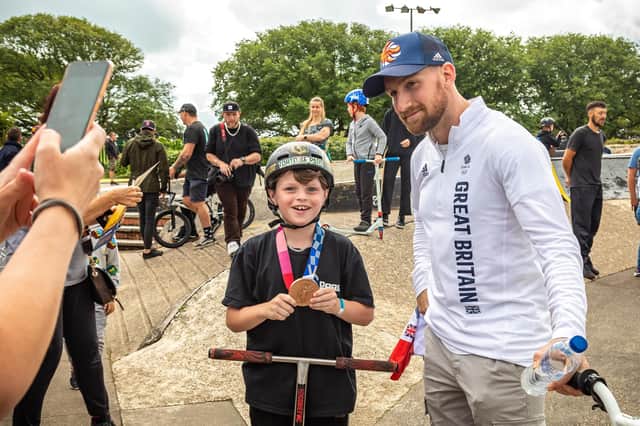 Declan Brooks allows fan Cobie Wenyon-Chambers, 10, to pose with his Olympic bronze medal for a photo at Southsea skatepark at the weekend. Cobie has been inspired by Declan's Tokyo achievements. Picture: Mike Cooter