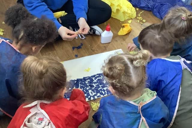 Children create art in blue and yellow. 