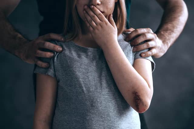 A man stands menacingly behind a young girl. Image posed by models. Photo: Shutterstock
