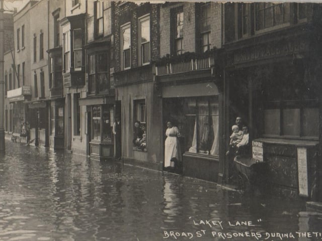A very old image of Broad Street, Old Portsmouth with the tide keeping residents prisoner.