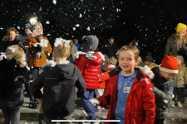 Children pictured playing in the fake snow being pumped out of Santa's sleigh during a festive event at Portchester Castle staged by the town's firefighters.