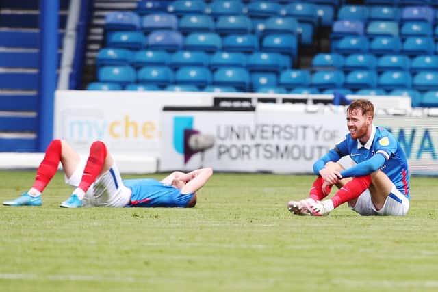 Jack Whatmough and Tom Naylor crestfallen after Pompey lost to Accrington to miss out on the League One play-offs. Picture: Joe Pepler