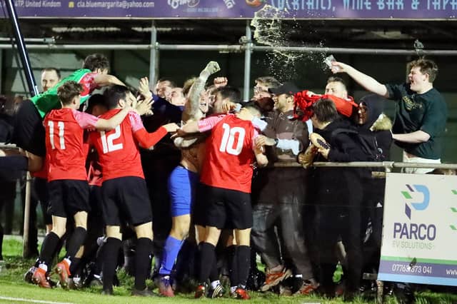 The drink goes flying as Fareham keeper Luke Deacon celebrates Fareham's penalty shoot-out win against Fleetlands. Picture by Ken Walker