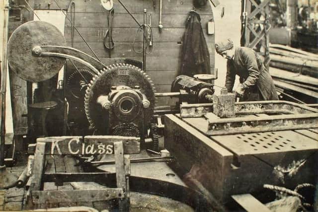 A female worker operates a drilling machine.