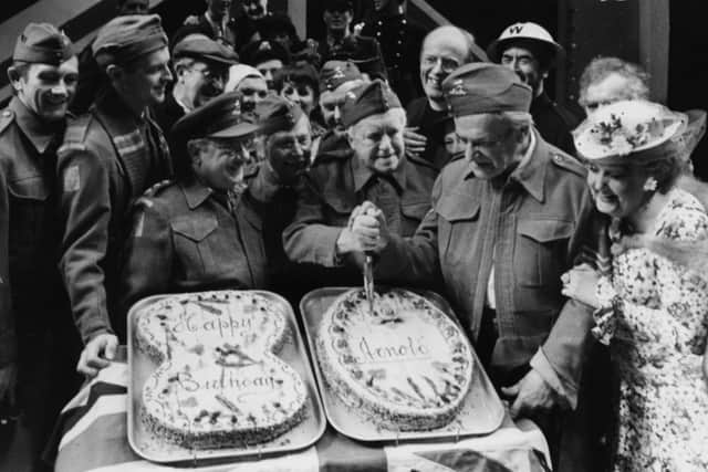 The cast of the BBC television show 'Dad's Army' in costume; (L-R) Talfryn Thomas, Ian Lavender, Arthur Lowe, Clive Dunn, Arnold Ridley and John le Mesurier, with Bill Pertwee and Frank Williams in the background, cutting a cake to celebrate the 80th birthday of Arnold Ridley on stage at the Shaftesbury Theatre, London, January 7th 1976. (Photo by Frank Barratt/Keystone/Getty Images)