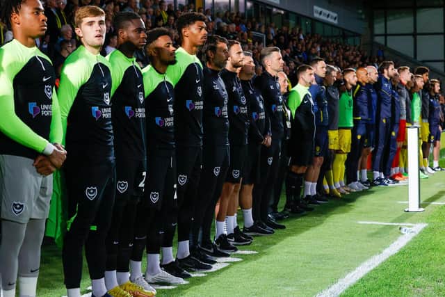 Pompey boss Danny Cowley, centre, along with his coaching staff and substitutes observe a minute's silence in respect of the late Queen ahead of tonight's game against Burton at the Pirelli Stadium Picture: Simon Davies.
