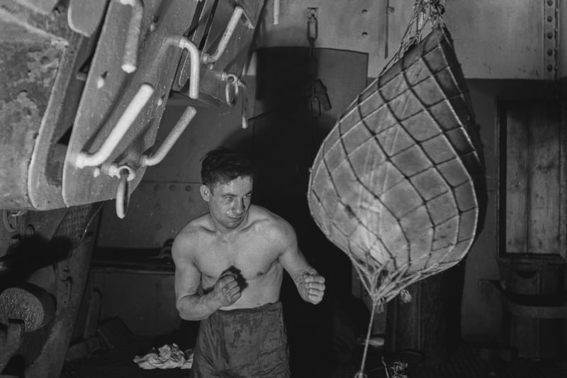 A crew member working out below decks with an improvised punchbag on a Royal Navy minesweeper during World War II, March 1941.  (Photo by Horace Abrahams/Keystone Features/Hulton Archive/Getty Images)