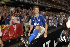 Hermann Hreidarsson jumps the fence to celebrate with the Pompey fans after the Blues' final victory against Liverpool on penalties.