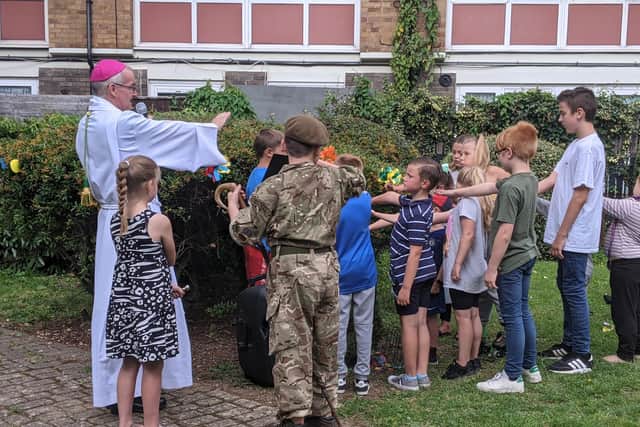 Bishop Paul blesses the new tree with the help of some of the children at the celebration. Picture: Emily Turner