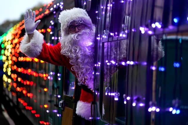 Santa Claus waves as he leans out of a carriage on a Steam Illuminations train, a light show on and in a steam train, consisting of thousands of fully controllable colour mixing LED lights, on the Watercress Line in Hampshire, which forms part of their Christmas programme of events. Picture date: Friday November 12, 2021. PA Photo. Photo credit should read: Andrew Matthews/PA Wire