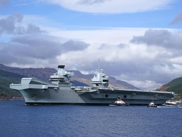 The Royal Navy aircraft carrier HMS Queen Elizabeth leaving Glen Mallan in Loch Long with the Arrochar Alps behind.