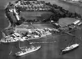 HMS Excellent on Whale Island aerial view 1970. Bottom right at her mooring is the Royal Yacht Britannia where she was always located when not in use. The grey ship to the left is HMS Rame Head that was a Canadian ship. She was a training ship later followed by HMS Bristol which still uses the birth to this day. Just above the playing field are the barrack blocks.