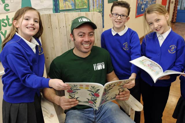 The large storyteller chair which was recently stolen from Orchard Lea Junior School in Fareham has been replaced with a new one from Go Create Care who work with adults with autism. Jermaine Broomes from the company reads to pupils as he tests the new chair. Left to right, Imogen Johns, nine, Ashleigh Beaven, nine, and Harry Middleton, nine. Picture Ian Hargreaves (040320-1)