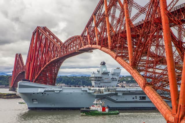 HMS Queen Elizabeth will be returning to Portsmouth soon after a length repair period in Rosyth, Scotland, to fix a propeller shaft misalignment fault. Pictured is the aircraft carrier sailing under the Forth Bridge  (Pic: Katielee Arrowsmith/SWNS)