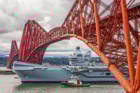 HMS Queen Elizabeth will be returning to Portsmouth soon after a length repair period in Rosyth, Scotland, to fix a propeller shaft misalignment fault. Pictured is the aircraft carrier sailing under the Forth Bridge  (Pic: Katielee Arrowsmith/SWNS)