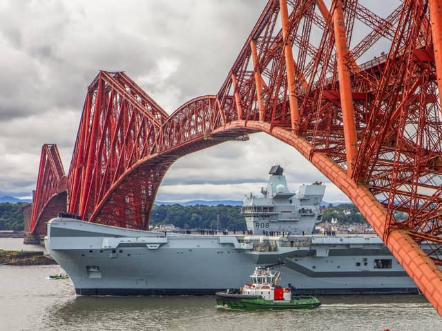 HMS Queen Elizabeth will be returning to Portsmouth soon after a length repair period in Rosyth, Scotland, to fix a propeller shaft misalignment fault. Pictured is the aircraft carrier sailing under the Forth Bridge  (Pic: Katielee Arrowsmith/SWNS)