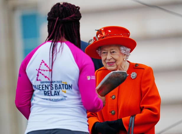Queen Elizabeth II passes her baton to the baton bearer, British parasport athlete Kadeena Cox, during the launch of the Queen's Baton Relay for Birmingham 2022, the XXII Commonwealth Games at Buckingham Palace on October 7, 2021 in London, England. The Queen and The Earl of Wessex are Patron and Vice-Patron of the Commonwealth Games Federation respectively. (Photo by Victoria Jones - WPA Pool/Getty Images)