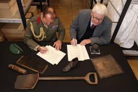 Member of staff from The National Museum of Royal Navy and Brigadier Jock Fraser MBE ADC signing the ‘deed of gift’ document.