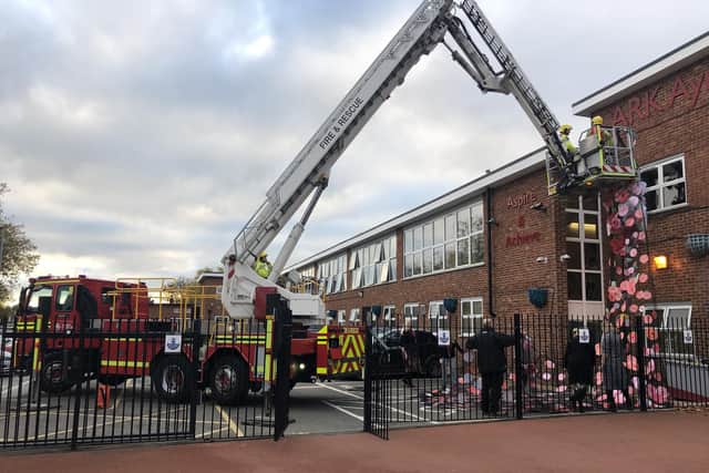 Crew from Southsea Fire Station helping assemble the poppy art installation at Ayrton Ark Academy