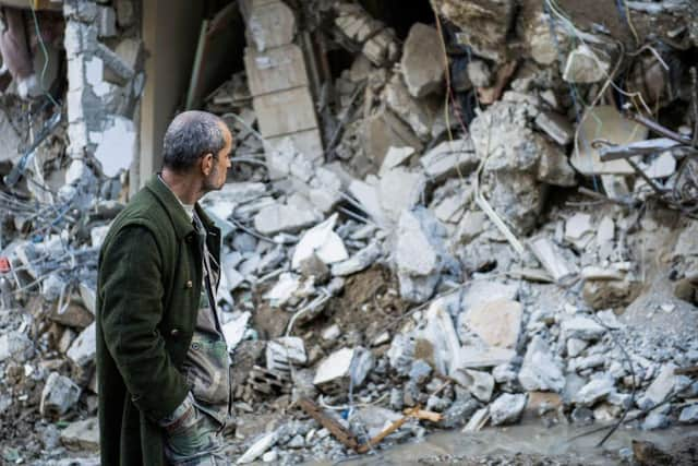 A man walks past a collapsed building in the town of Jbaleh in Syria's northwestern province of Latakia following the earthquake.