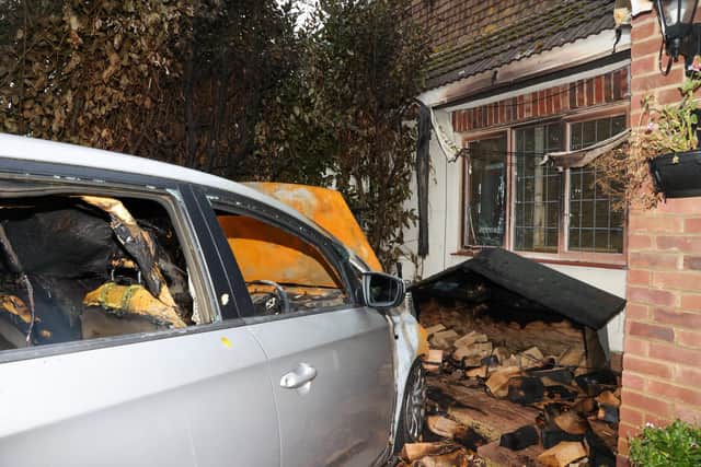 The remains of Cathie Ingram's car and resulting damage to her house after it burst into flames in the middle of the night. Picture: Alex Shute