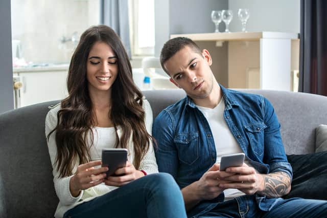 Jealous boyfriend spying his girlfriend's phone. Credit: Shutterstock