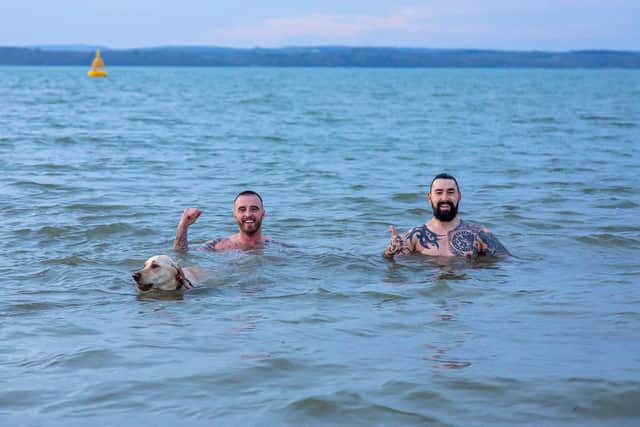 Joey Duffy (34), Joe Small (33) and dog Mia take a dawn swim at Stokes Bay. Picture: Mike Cooter (010122)