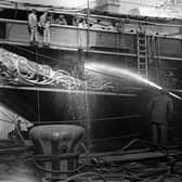 1925:  Men testing the portholes of the royal yacht Victoria and Albert with a hose, in preparation for her setting sail from Portsmouth.  Picture: Hulton Archive/Getty Images.